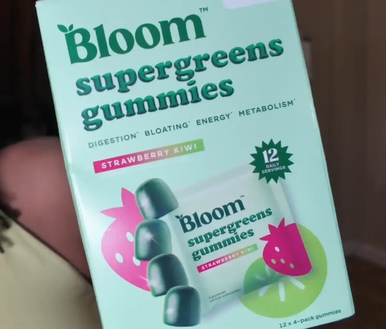 Creator holding a Bloom Nutrition tub in a kitchen