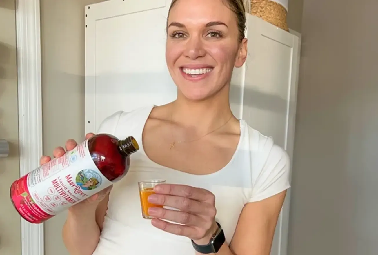 Creator holding a MaryRuth Organics bottle in a kitchen