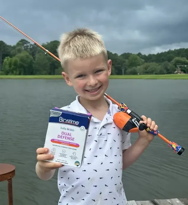 Child holding a Biostime supplement box