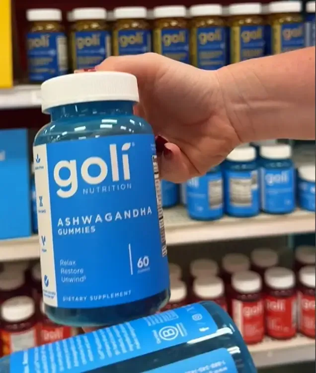 Hand holding a bottle of Goli Ashwagandha Gummies in store