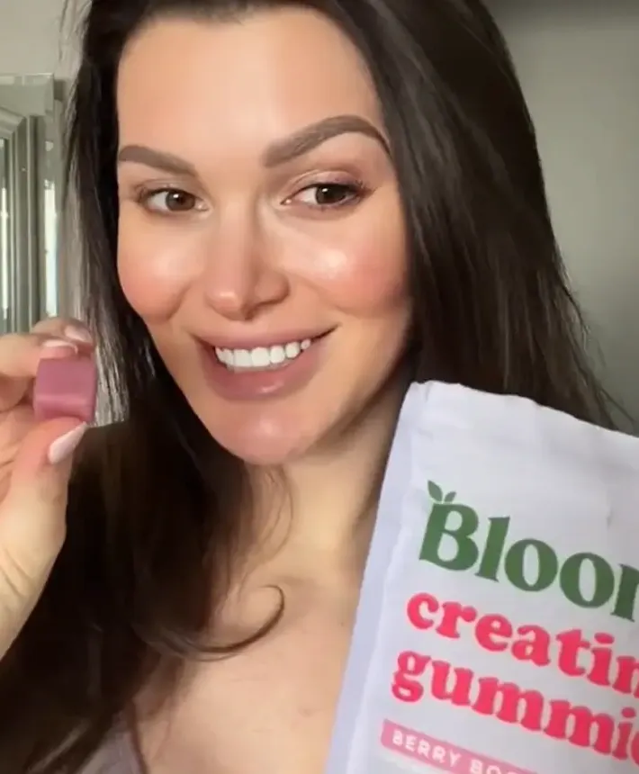 Creator holding a Bloom Nutrition greens sachet