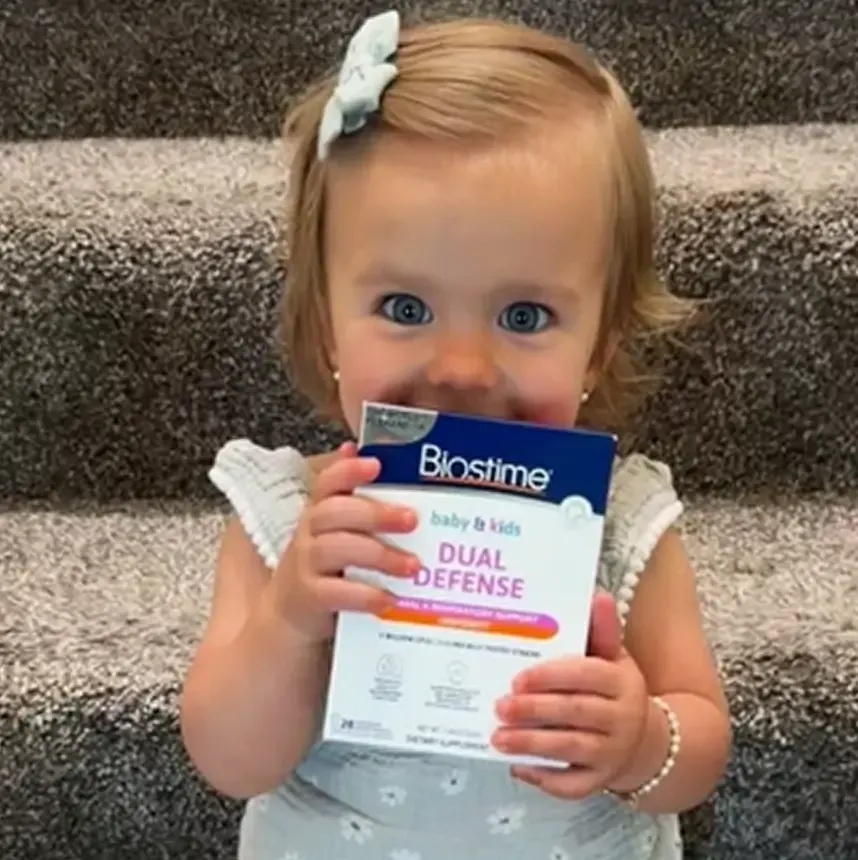 Toddler holding a Biostime product box