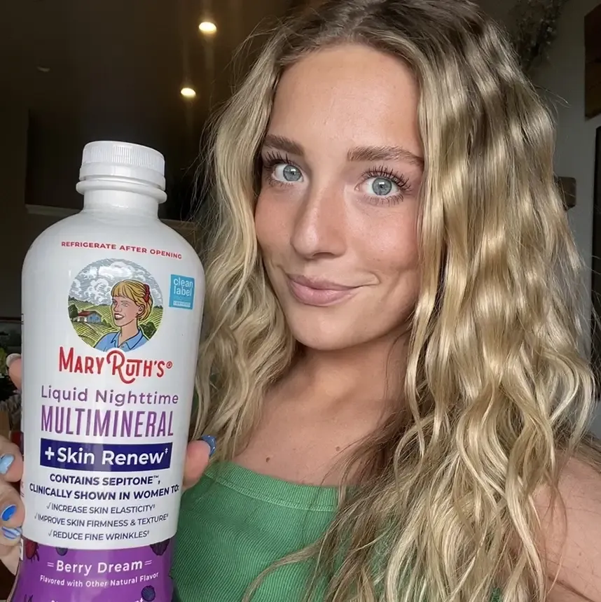 MaryRuth Organics creator holding a liquid multimineral bottle