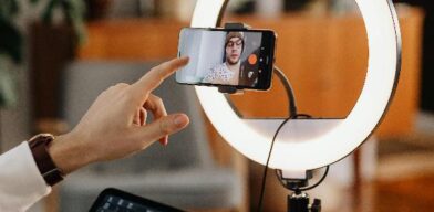 An image of a man recording a video of himself using a mobile phone.