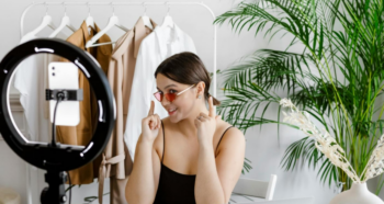 Female content creator pointing to her sunglasses while recording