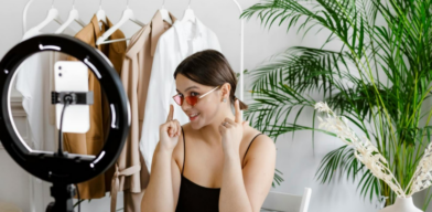 Female content creator pointing to her sunglasses while recording