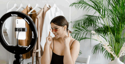 Female content creator pointing to her sunglasses while recording