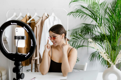 Female content creator pointing to her sunglasses while recording